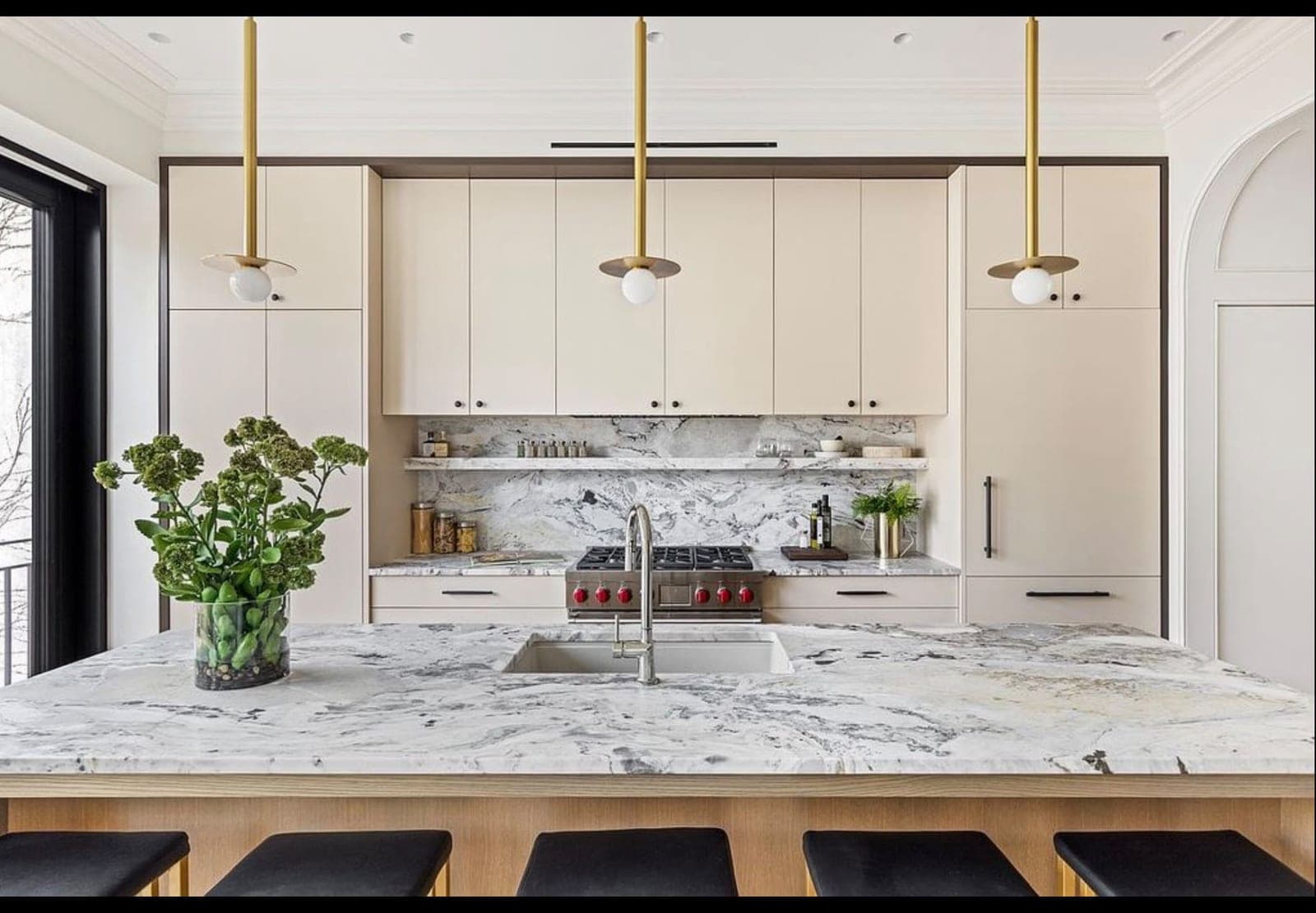 Finished kitchen with a marble island, sink and pendant lights