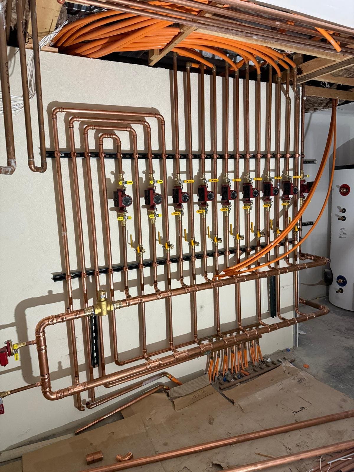 Copper heating manifold with circulator pumps and zone valves feeding radiant floor heating